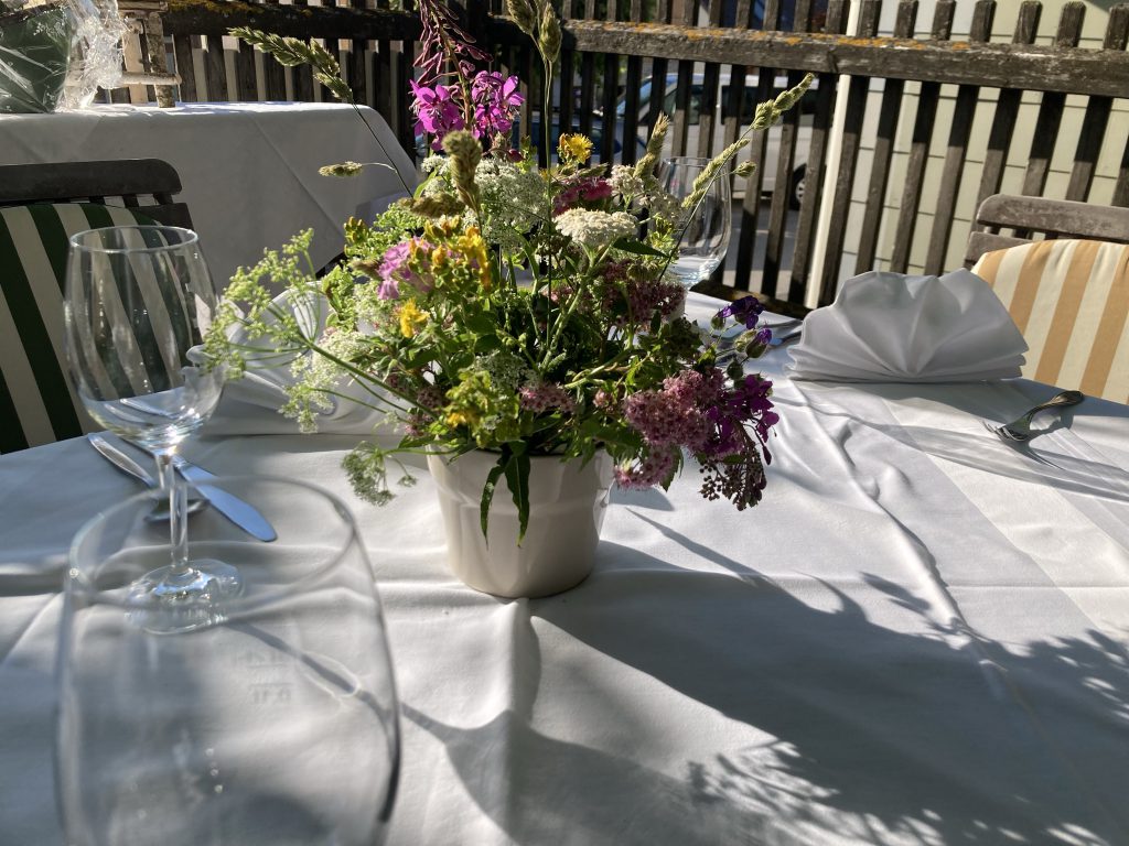 festlich gedeckter Tisch im Garten mit Blumen
